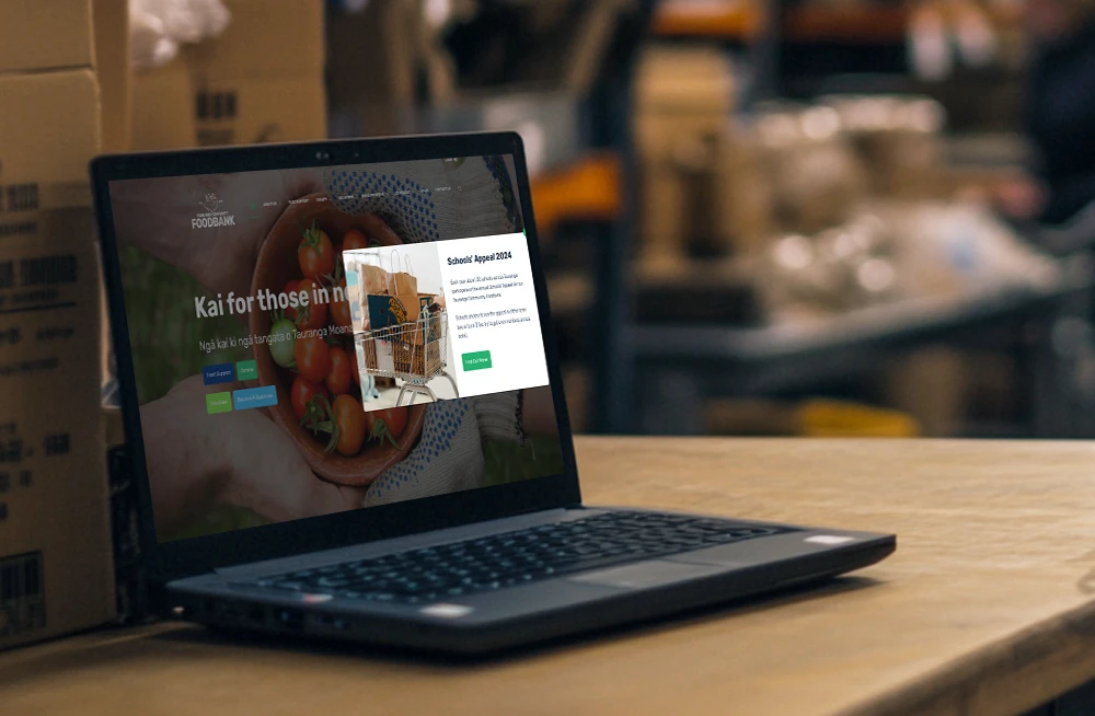 Responsive, Tauranga digital design agency. Client project  - Tauranga Community Foodbank, Website development, web hosting, Tauranga Community Foodbank - campaigns popup on a laptop